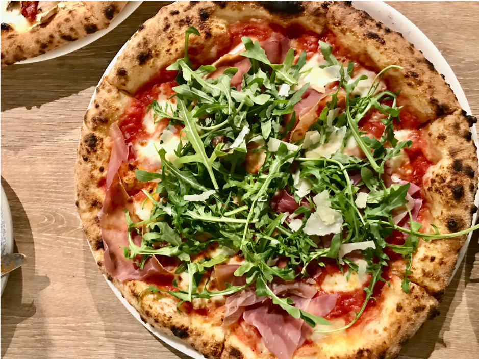 A pizza sitting on top of a wooden table

Description automatically generated