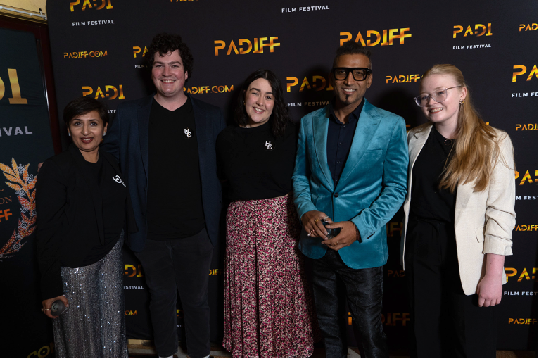Five people standing in a line posing for photo at PADIFF